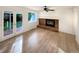 Bright living room features a brick fireplace, hardwood floors, and sliding glass doors to the backyard at 14822 E Adriatic Pl, Aurora, CO 80014