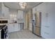 Bright kitchen featuring stainless steel appliances, white cabinets, and hexagon tile floors at 5191 S Logan St, Littleton, CO 80121