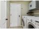 Functional laundry room with modern washer and dryer units and storage cabinets at 17162 E Atlantic Pl, Aurora, CO 80013