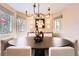 Elegant dining room with modern chandelier, large windows, and stylish decor at 6961 Salvia St, Arvada, CO 80007