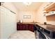 Laundry room featuring wooden cabinets, tile flooring, and a modern washer and dryer at 6961 Salvia St, Arvada, CO 80007