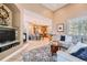 Cozy living room open to kitchen featuring a fireplace, tv, and access to all living areas at 6961 Salvia St, Arvada, CO 80007