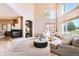Bright living room features a fireplace, large windows, and neutral-toned furniture at 6961 Salvia St, Arvada, CO 80007