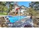 Stunning backyard pool with a waterfall feature, surrounded by a spacious patio and lush landscaping at 6961 Salvia St, Arvada, CO 80007
