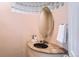 Stylish powder room featuring an oval mirror, glass block detail, and a unique granite countertop at 6961 Salvia St, Arvada, CO 80007