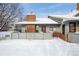 Charming home with a red brick chimney, inviting entryway, and snow-covered yard at 3079 E Long S Cir, Centennial, CO 80122