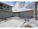 Attached garages and driveway blanketed in snow, complemented by the siding and winter landscape at 3079 E Long S Cir, Centennial, CO 80122