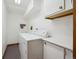 Bright laundry room featuring a white washer and dryer with a cabinet and hanging rack at 3079 E Long S Cir, Centennial, CO 80122