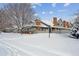 Exterior view of a multi-unit townhouse covered in snow, set against a clear blue sky at 3079 E Long S Cir, Centennial, CO 80122