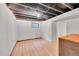 Unfinished basement features an exposed ceiling, light wood flooring, and a small window at 1342 S Andes St, Aurora, CO 80017