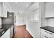 Bright kitchen with stainless steel appliances, white cabinets, black countertops, and hardwood floors at 1342 S Andes St, Aurora, CO 80017