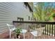 Outdoor back deck with wood railing, showing furniture, a plant, and treed outdoor views at 4863 Silver Spruce Ln, Evergreen, CO 80439
