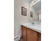 Powder room featuring a white sink, vanity, a decorative painting, and a large mirror at 4863 Silver Spruce Ln, Evergreen, CO 80439