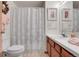 Bathroom featuring a toilet, shower with patterned curtain, wood vanity, and decorative art at 4863 Silver Spruce Ln, Evergreen, CO 80439