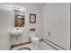 Bathroom featuring a floating sink, toilet, a mirror, and a window at 4863 Silver Spruce Ln, Evergreen, CO 80439