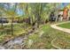 A serene creek flows near a sidewalk and townhomes in a tree-filled, landscaped community at 4863 Silver Spruce Ln, Evergreen, CO 80439