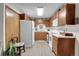 Functional kitchen featuring wood cabinets, white appliances, and tile flooring for easy maintenance at 4863 Silver Spruce Ln, Evergreen, CO 80439