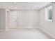 Neutrally decorated bedroom showcasing light carpet, neutral walls, a window, and a paneled door at 260 S Jasmine St, Denver, CO 80224