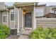 Welcoming entrance features a decorative door with porch cover, lush plants and walkway, and efficient air conditioning at 6839 Zenobia St # 3, Westminster, CO 80030