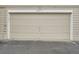 Attached one car garage with beige door at 6839 Zenobia St # 3, Westminster, CO 80030