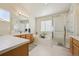 Bright bathroom features a white countertop, wood cabinets, and a tiled tub and shower at 12453 Knox Ct, Broomfield, CO 80020