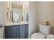 A half-bathroom with a neutral color scheme, featuring gray cabinetry and a white toilet and sink at 12453 Knox Ct, Broomfield, CO 80020