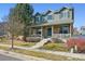 Charming two-story home with brick and siding, a covered porch, and manicured landscaping at 12453 Knox Ct, Broomfield, CO 80020