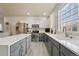 The kitchen features stainless steel appliances, white countertops, gray and white cabinets, and wood flooring at 12453 Knox Ct, Broomfield, CO 80020