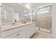 Bright bathroom featuring double sinks, quartz counters, and walk-in shower with neutral tilework at 3373 N Catawba Way, Aurora, CO 80019