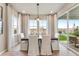 Sunlit dining area with white chairs, a dark wood table, and sliding glass doors offering outdoor views at 3373 N Catawba Way, Aurora, CO 80019