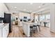 Bright, modern kitchen with white cabinets, stainless steel appliances, and a center island with seating, open to the dining area at 3373 N Catawba Way, Aurora, CO 80019