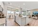 Open-concept kitchen with white cabinets, stainless steel appliances, a center island, and seamless flow into the dining and living areas at 3373 N Catawba Way, Aurora, CO 80019