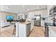Bright, open kitchen featuring white cabinetry, stainless steel appliances, and an island with breakfast bar, next to the living area at 3373 N Catawba Way, Aurora, CO 80019
