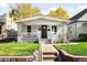 Charming home featuring a well-manicured front yard, covered porch, and classic architectural details at 3884 Osceola St, Denver, CO 80212