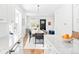 Stylish kitchen open to the dining area, featuring stainless steel appliances and white cabinetry at 3884 Osceola St, Denver, CO 80212