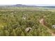 Breathtaking aerial view of a tree-lined neighborhood with stunning mountain views in the distance at 4407 Delaware Dr, Larkspur, CO 80118