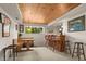 A cozy bar area with a knotty pine ceiling, built in bench, table and window to the outside at 4407 Delaware Dr, Larkspur, CO 80118
