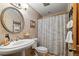 Bathroom featuring wallpaper, pedestal sink, and framed artwork at 4407 Delaware Dr, Larkspur, CO 80118