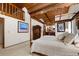 Large bedroom with wood ceiling, canopy bed, and a view to the ensuite bathroom at 4407 Delaware Dr, Larkspur, CO 80118