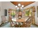 Light filled dining room features wood ceiling, large windows and a stylish chandelier at 4407 Delaware Dr, Larkspur, CO 80118