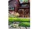 Beautiful front exterior of a wood home featuring mature landscaping and a stone walkway at 4407 Delaware Dr, Larkspur, CO 80118