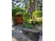 Inviting garden gate with lush greenery, a rustic bench, and a serene woodland setting at 4407 Delaware Dr, Larkspur, CO 80118