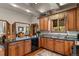 Charming kitchen features warm wood cabinets, stone countertops and views to the adjacent dining room at 4407 Delaware Dr, Larkspur, CO 80118