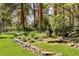 Lush backyard landscaping with a stone retaining wall and beautiful garden at 4407 Delaware Dr, Larkspur, CO 80118
