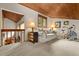 Bright living room with wood ceiling, comfortable seating area, and exercise bike at 4407 Delaware Dr, Larkspur, CO 80118