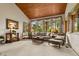 A spacious living room with a wood ceiling, carpet, and large windows with serene views at 4407 Delaware Dr, Larkspur, CO 80118