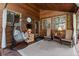 Cozy sun room featuring comfortable seating, warm wood accents, and serene outdoor views at 4407 Delaware Dr, Larkspur, CO 80118