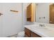 Neat bathroom with wooden vanity, white sink and toilet offering comfortable space at 892 Summer Dr # 15B, Highlands Ranch, CO 80126