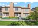 Inviting townhome exterior with brick chimney, manicured lawn and well-maintained landscaping at 892 Summer Dr # 15B, Highlands Ranch, CO 80126