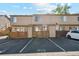 Exterior facade of a row of townhomes with reserved parking spaces in front at 892 Summer Dr # 15B, Highlands Ranch, CO 80126